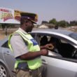 An officer checks a motorist's driver's licence at a checkpoint: File Picture