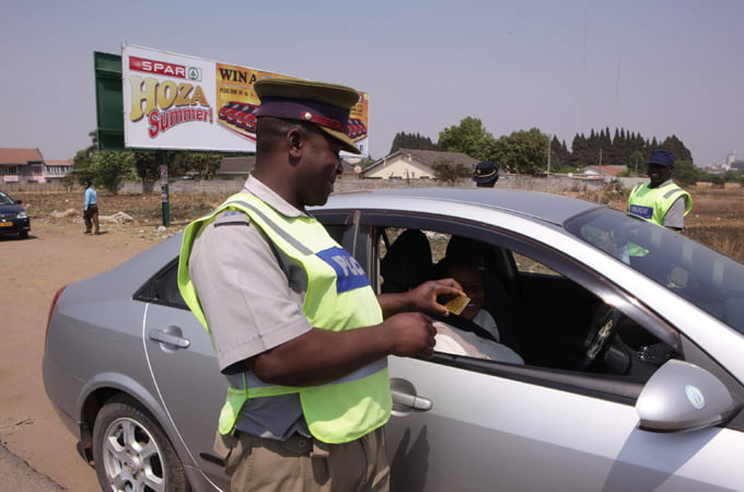 An officer checks a motorist's driver's licence at a checkpoint: File Picture